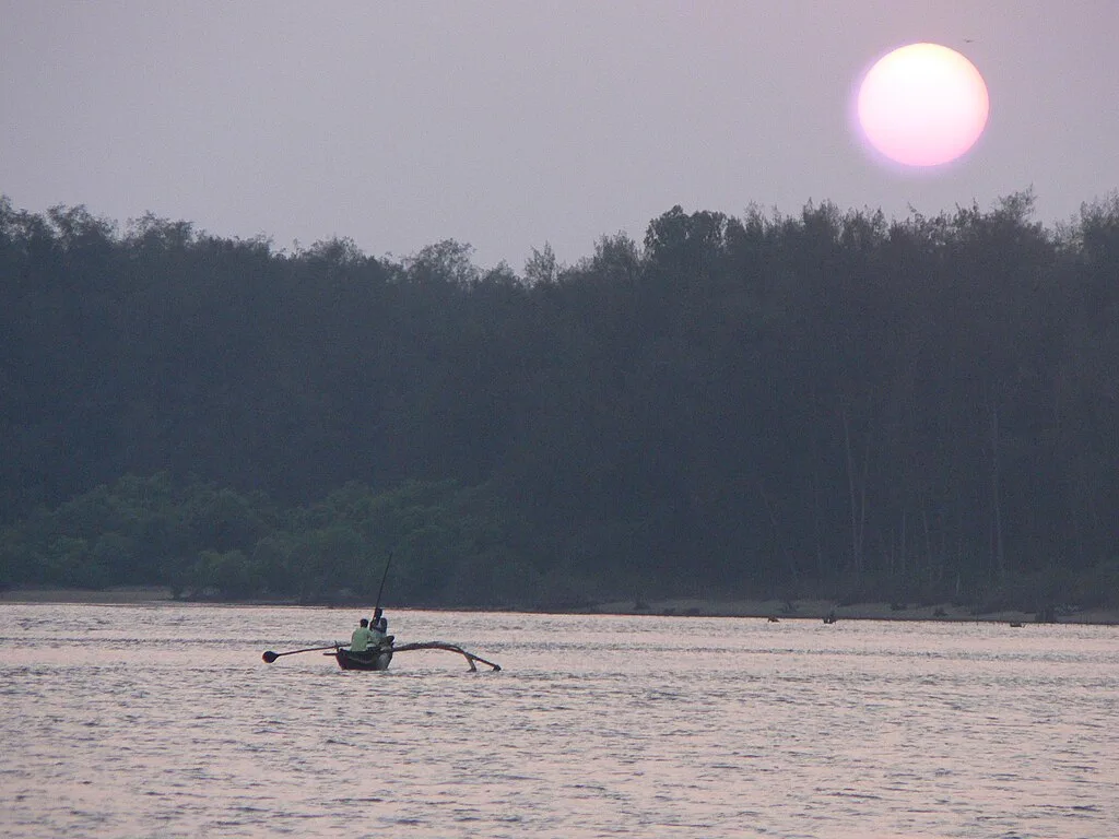 A beautiful capture of the fisherman on a boat returning home at Sunset